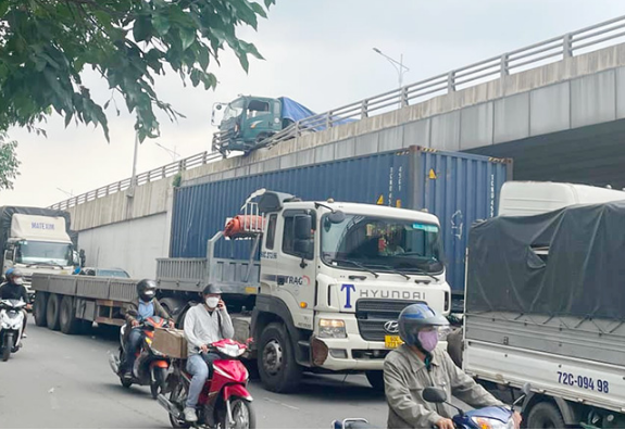 Xe ben tông hàng loạt dải phân cách, nằm vắt vẻo trên thành cầu vượt