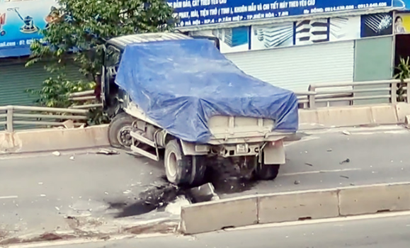 Xe ben tông hàng loạt dải phân cách, nằm vắt vẻo trên thành cầu vượt